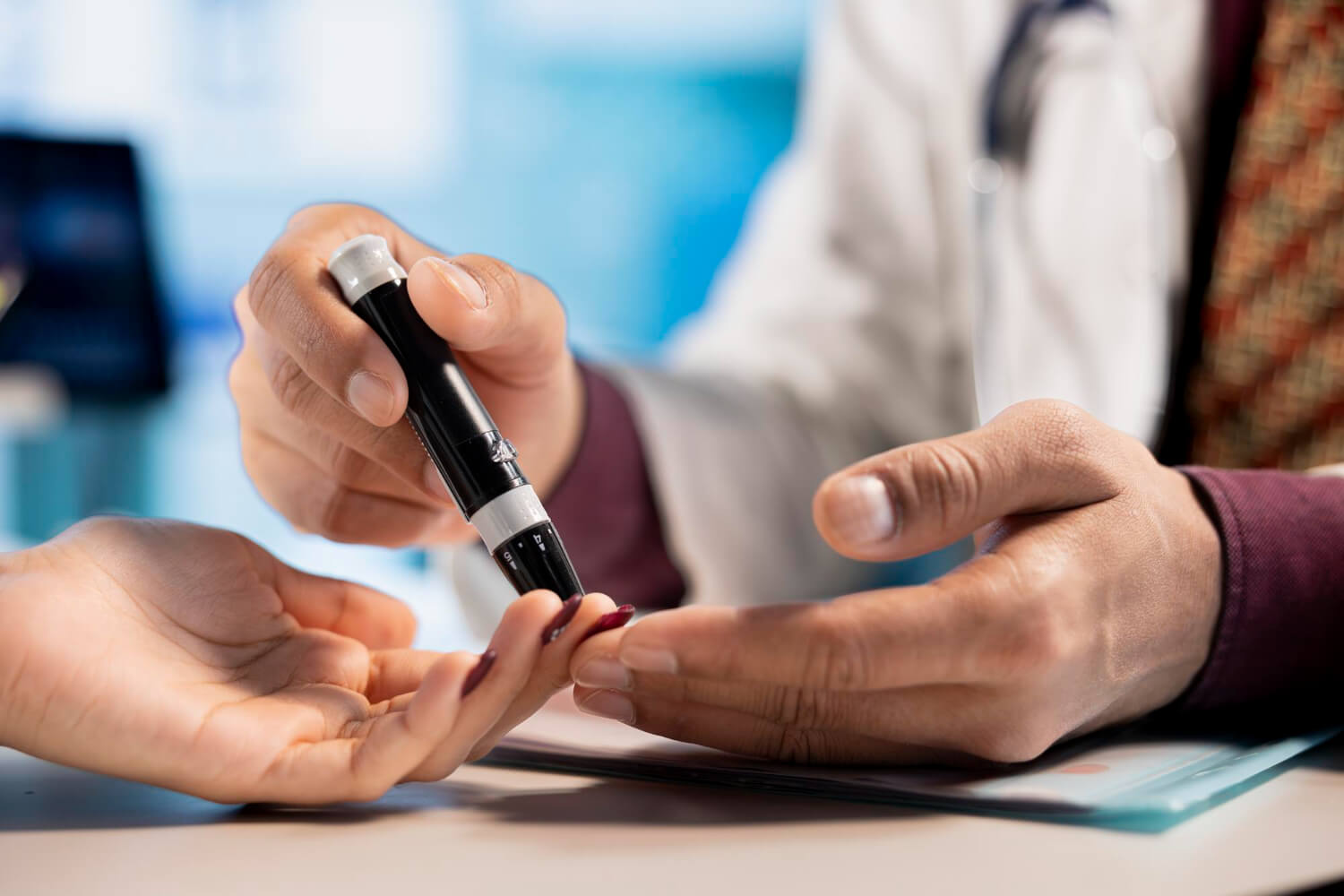A healthcare professional using a lancing device on a patient's fingertip to perform a blood glucose test.